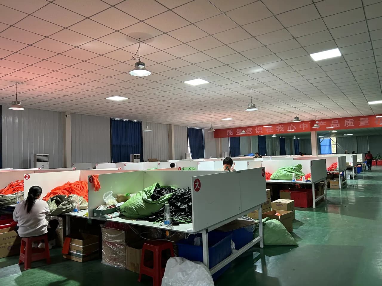 Factory packing center with workers preparing gloves for shipment