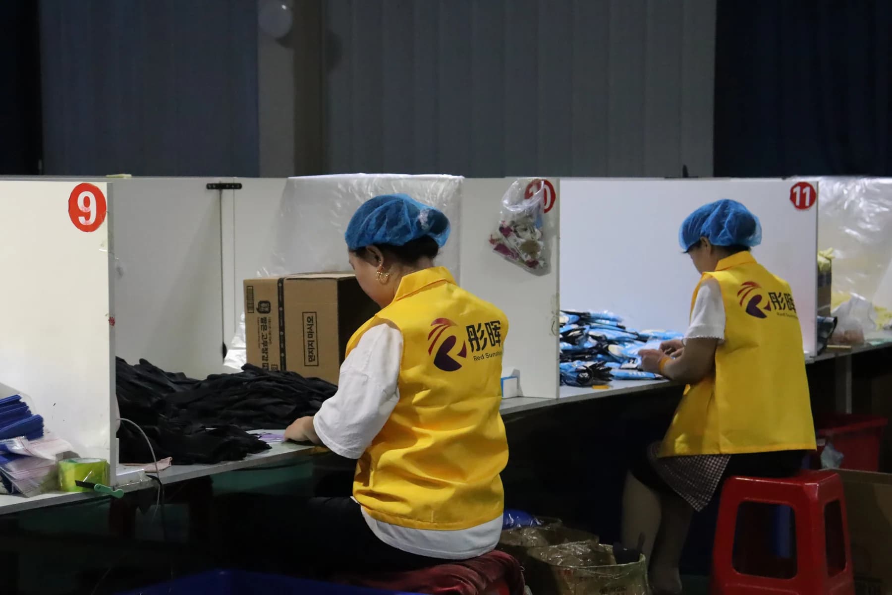 Factory packing center with workers preparing gloves for shipment